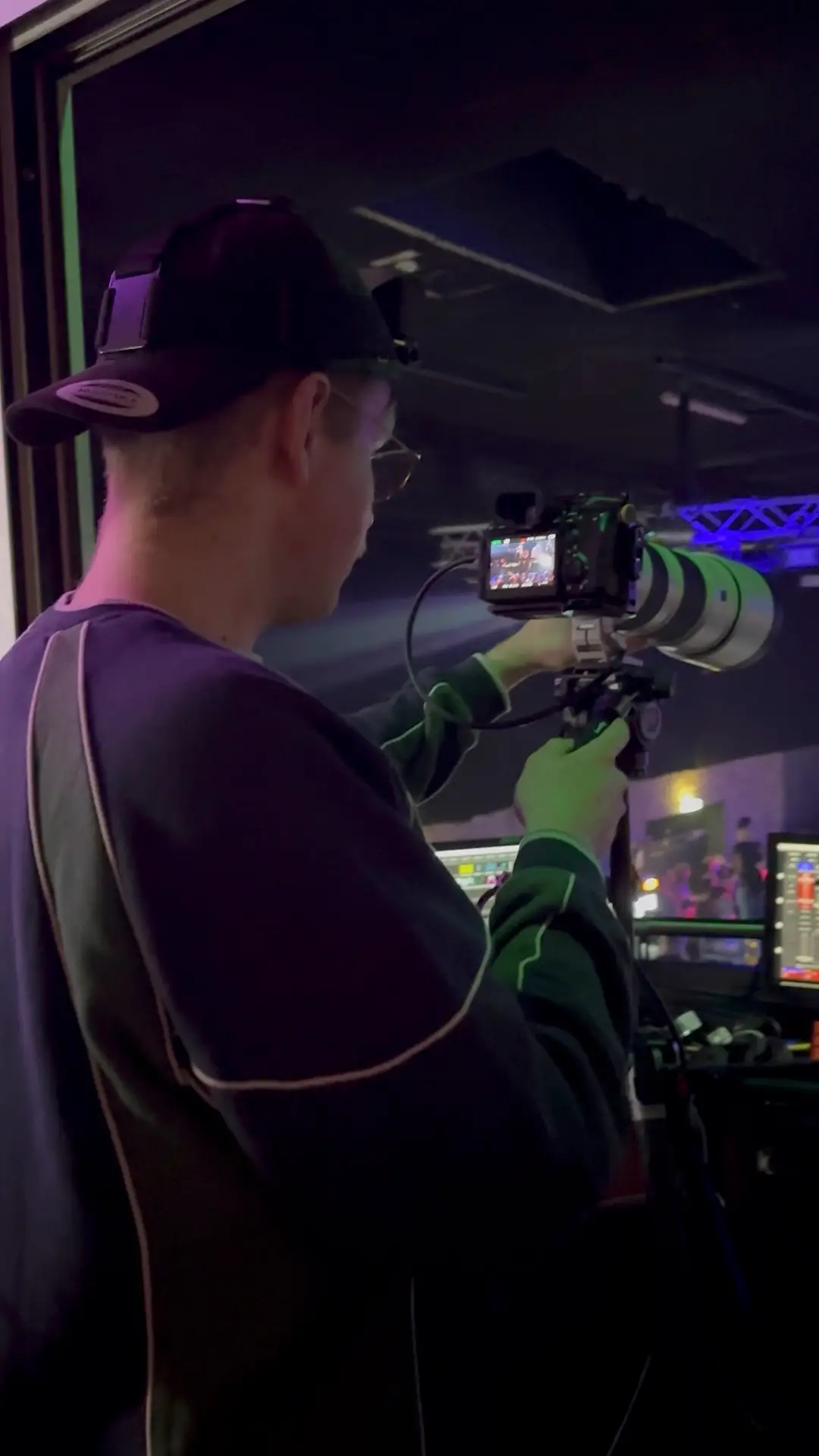 Kameramann mit Kappe und Gimbal filmt den Auftritt von der Bühne aus