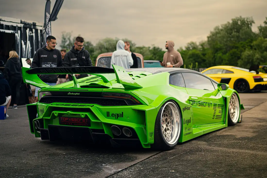 Grüner Lamborghini mit Heckflügel bei einem Tuning-Treffen