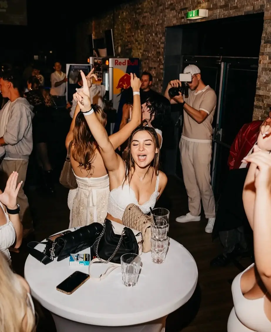 Fotograf mit Kamera zwischen tanzenden Gästen bei der All White Party