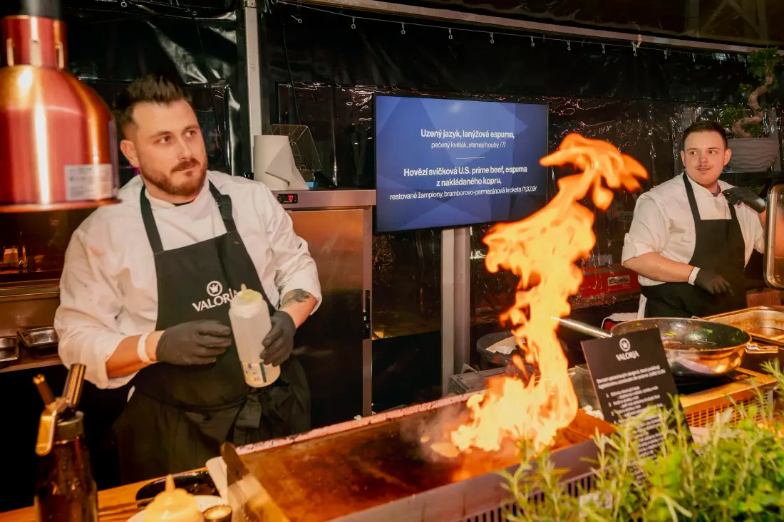 Zwei Köche beim Flambieren an einer Showküche