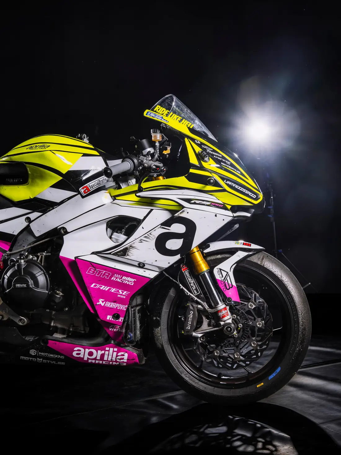 Rennmotorrad von Aprilia im Gegenlicht vor schwarzem Hintergrund