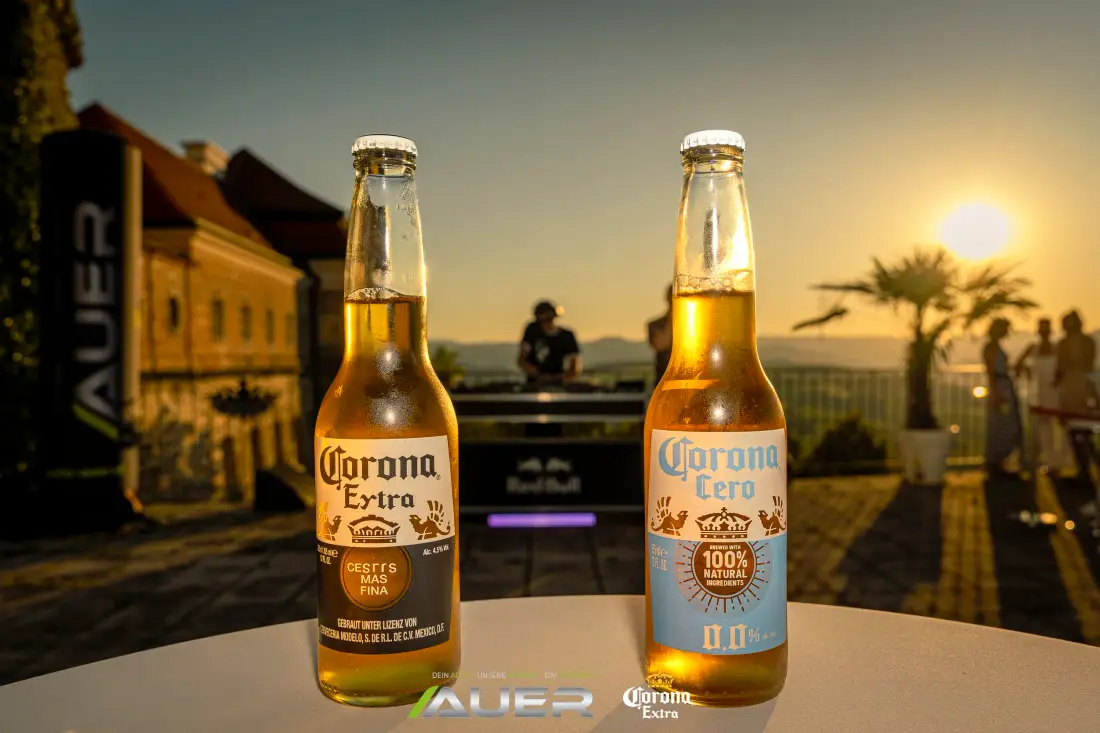 Two beer bottles on a high table in the evening light