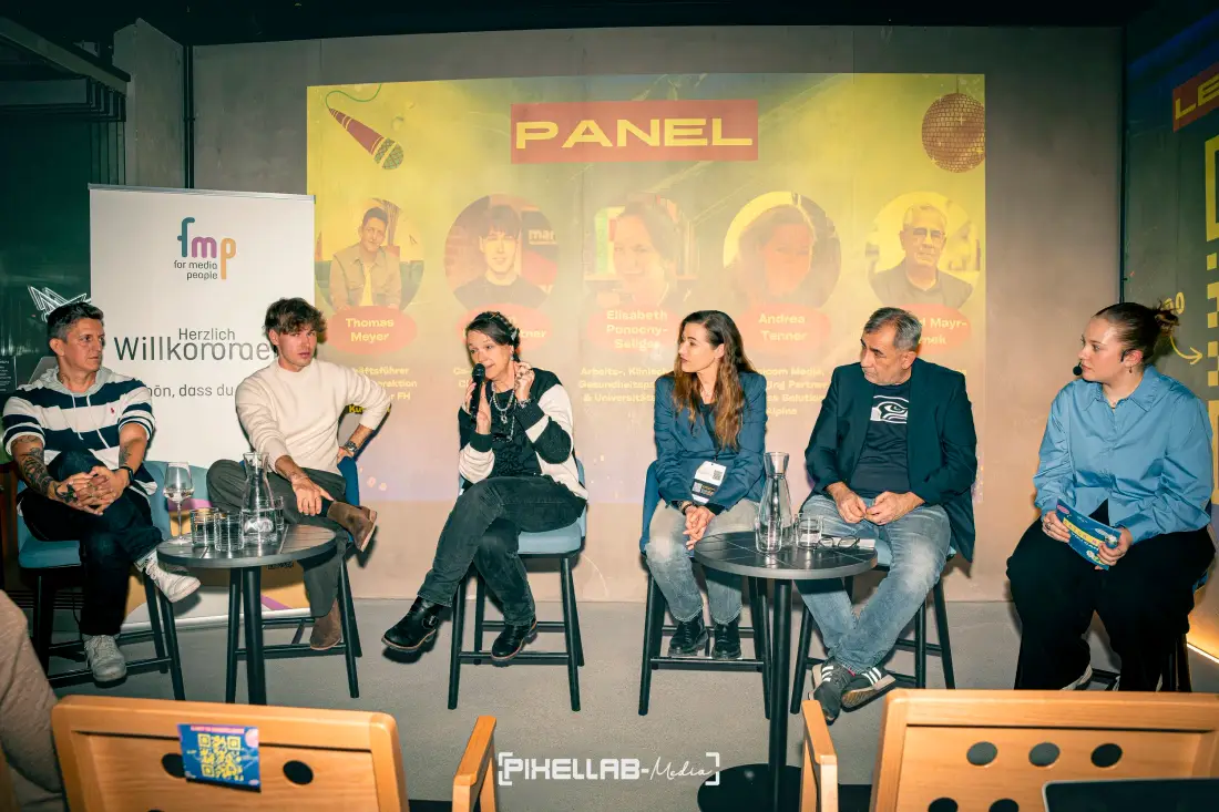 Podiumsdiskussion mit sechs Personen auf einer Bühne