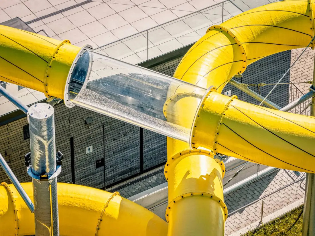 Detail from above: transparent tube between yellow Aquarena slide sections