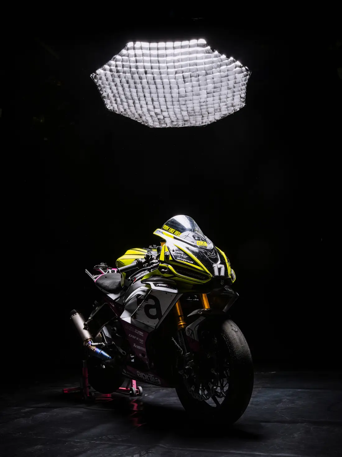 Racing motorbike in a dark studio under a large softbox