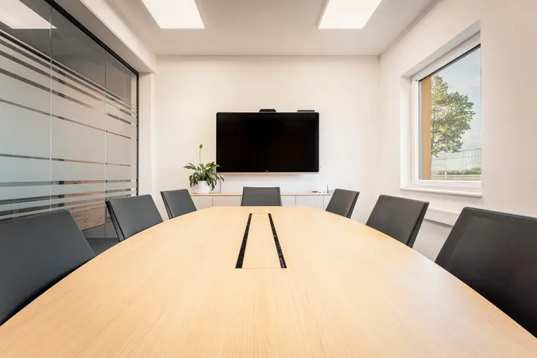 Besprechungsraum mit großem Tisch und Bildschirm