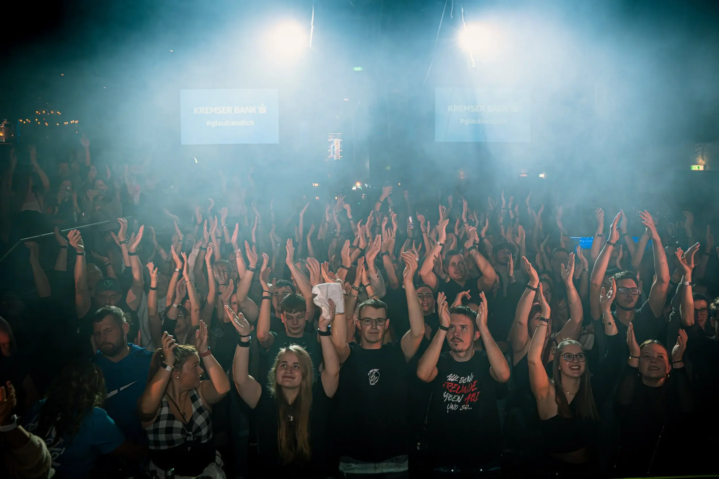 Publikum klatscht im blauen Bühnenlicht