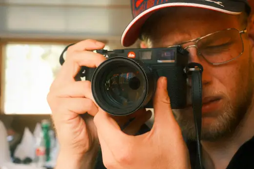 Fotograf blickt durch den Sucher seiner Kamera