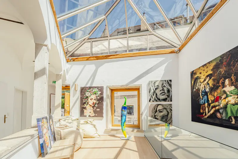Heller Galerieraum mit Glasdach und Gemälden