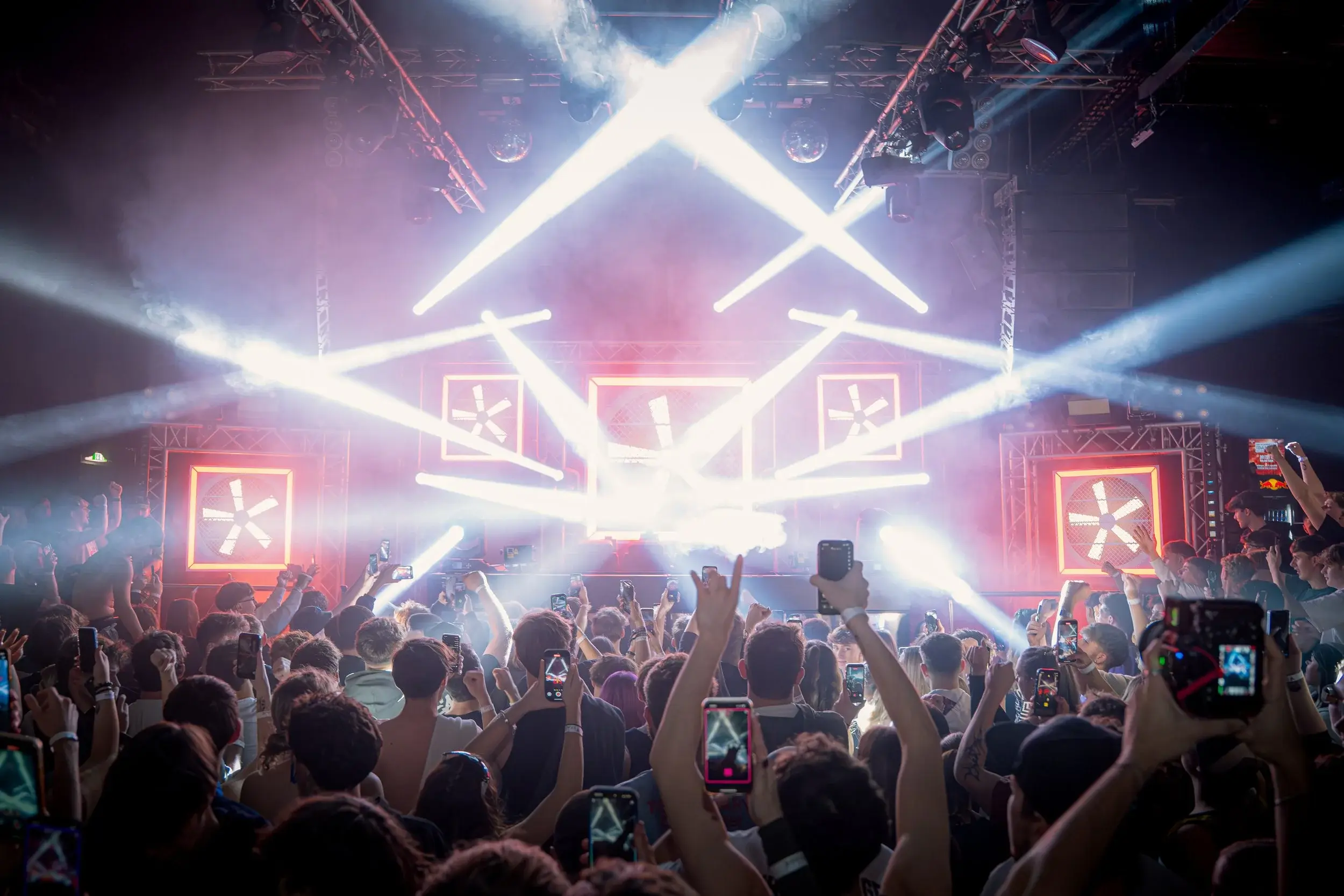Concert stage with crossing light beams and an audience